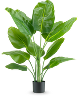 De Kunstplant Strelitzia Real Touch Deluxe 120 cm heeft brede, glanzend groene bladeren op lange stelen, in een eenvoudige zwarte pot en tegen een effen witte achtergrond.