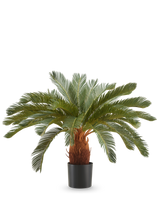 De Kunstplant Cycas UV 90 cm heeft lange, gebogen groene bladeren en een dikke bruine stam in een zwarte pot, tegen een effen witte achtergrond.