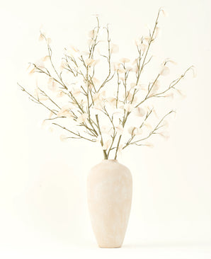 Het Zijden kunstbloemen boeket Eucalyptus crème in een hoge, lichtbeige keramische vaas met transparante witte bladeren zorgt voor een serene sfeer in elk kunstbloemen interieur tegen een lichte achtergrond.