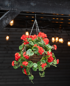 De Kunstbegonia Rood in Mand UV 70cm heeft levendige rode kunstbegonia's en weelderige groene bladeren in een hangende mand, perfect om kleur toe te voegen onder warme strijklichtjes binnen of buiten.