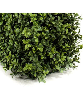 Gros plan de feuilles denses et vertes sur la haie de buis artificiel UV 70x20x25 cm qui forme une haie artificielle luxuriante avec un petit feuillage rond de différentes nuances. Un coin épais et carré est visible en bas à gauche.