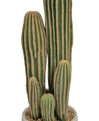 Un gros plan du cactus artificiel 59 cm montre plusieurs longues tiges vertes nervurées avec des crêtes verticales jaunâtres dans un pot blanc rempli de petits cailloux.