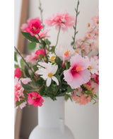 De Kunstbloem Margriet 60 cm wit/roze, een witte vaas met roze en witte kunstmargrieten, staat tegen een lichte, neutrale achtergrond.
