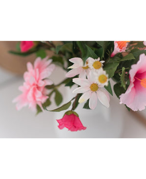 Een close-up van Kunstbloem Margriet 60 cm wit/roze toont roze en witte margrieten met een geel hart in een witte vaas tegen een neutrale achtergrond.