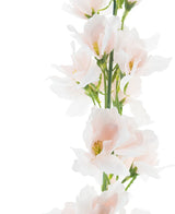 Een close-up van de Kunstbloem Ridderspoor Real Touch champagnepa 90 cm, met zachtroze bloemen met fijne bloemblaadjes en gele hartjes tegen een helderwitte achtergrond.