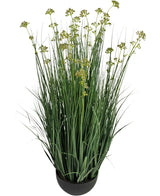 De Kunstgras Prei Bloem Ui Graspot 100cm brandvertragend heeft lange, slanke groene grasachtige bladeren en kleine geelgroene bloemtrosjes in een ronde zwarte pot, tegen een witte achtergrond.