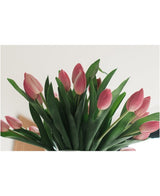 Het Zijden kunstboeket Tulpen in vaas Roze toont roze tulpen met groene bladeren, tegen een lichte achtergrond en van onderaf gezien.