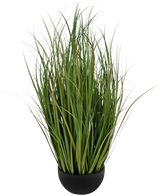 Le gazon artificiel Dogtail Onion Grass Bran 90 cm ignifuge est un pot noir avec des feuilles denses, hautes, fines, vertes, ressemblant à de l'herbe, qui se tiennent debout, représentées sur un fond blanc.