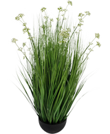 Le gazon artificiel poireau fleur oignon herbe pot 100 cm ignifuge est une plante de gazon artificiel dans un pot avec de longues lames minces et de petites grappes de fleurs blanches dans un pot rond noir, représenté sur un fond blanc uni.