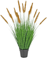 Le gazon artificiel d'autruche de 100 cm ignifuge se présente dans un pot noir avec de hautes feuilles ressemblant à de l'herbe et de longues plumes brunes, qui ajoutent une décoration verte sur un fond blanc uni.